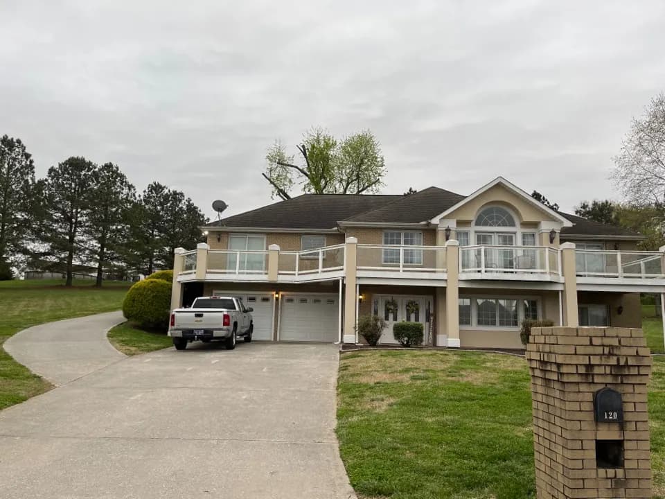 Two-story house with wraparound balconies and a pickup in the driveway, Kingston