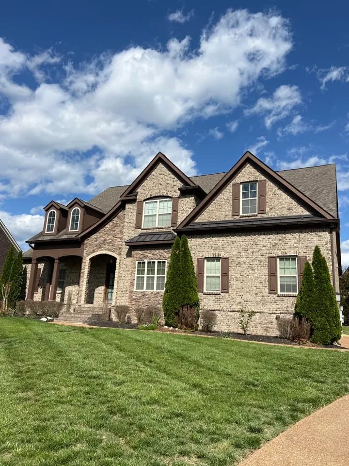 Large brick and stone house with a dark shingle roof, Brentwood