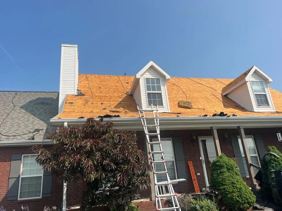 Roof replacement in progress with new decking and a ladder against a brick house, Murfreesboro