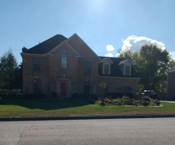 Brick two-story house under a bright sky, Farragut