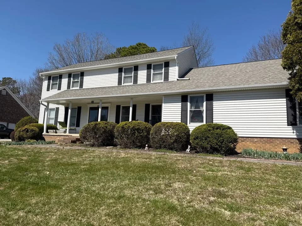 Roofer inspecting a shingle roof for wind damage, from a Farragut job photo