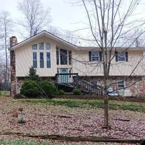 Two-story house with a stone chimney and a front deck, Clinton