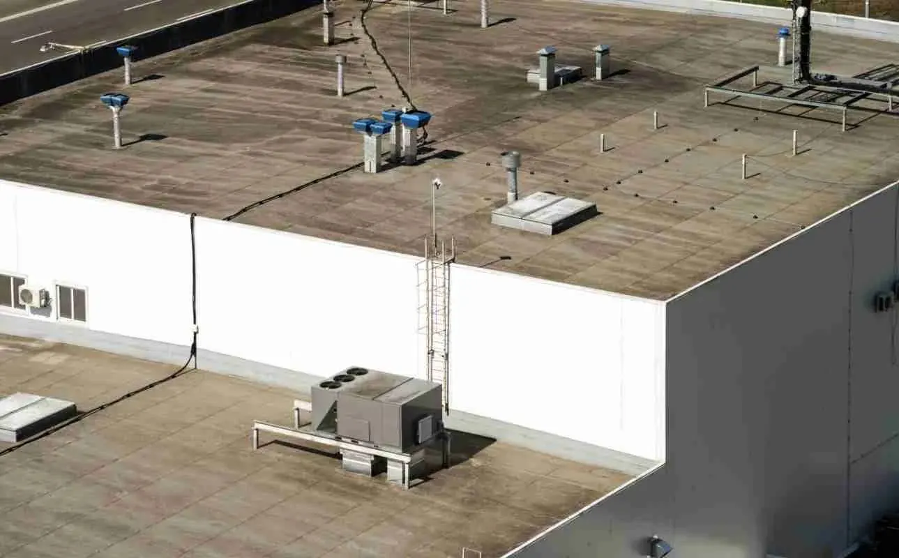 Aerial view of a flat commercial roof with rooftop HVAC units and vents
