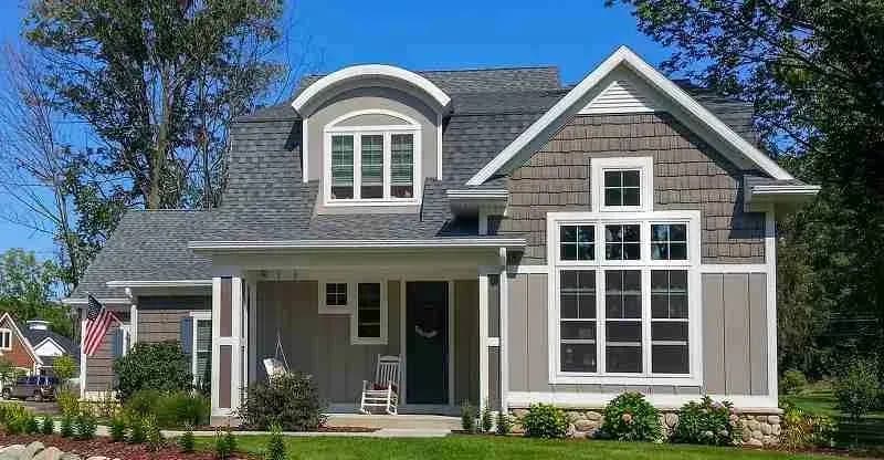 Gray shake-sided house with a shingle roof and front porch