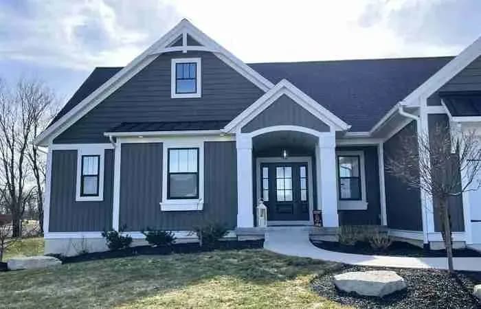 Dark blue board-and-batten house with a white-trimmed entry