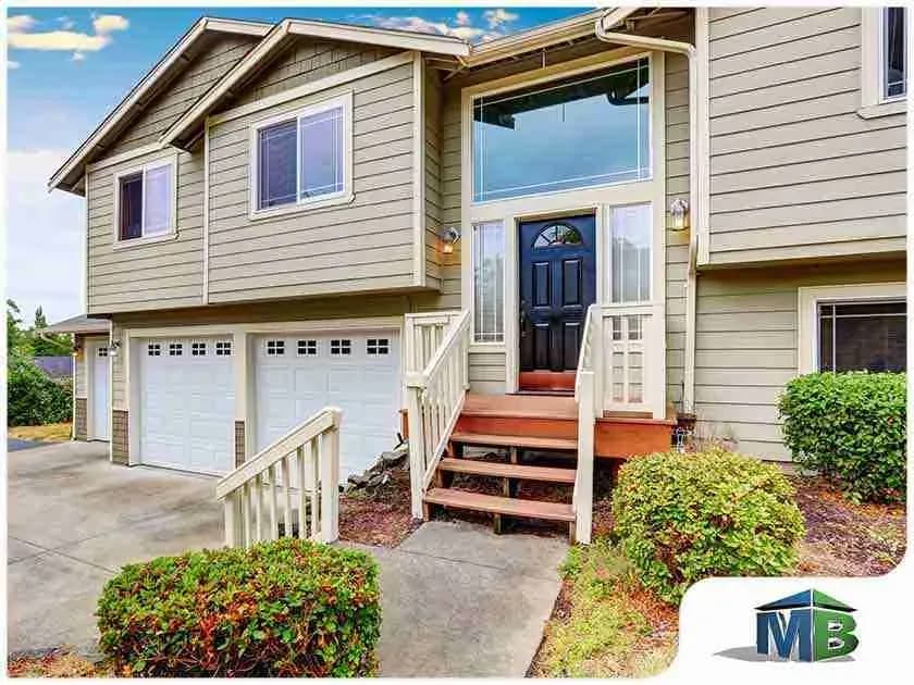 Tan split-level house with lap siding and a two-car garage