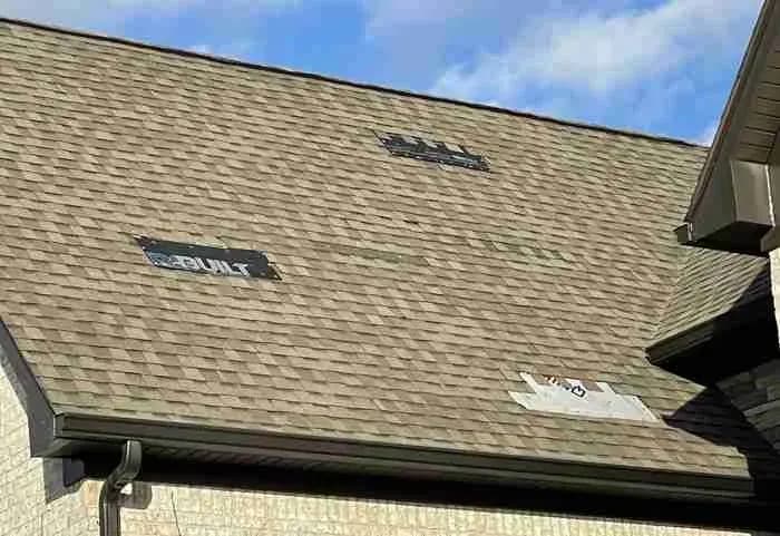 Shingle roof with a few replaced and patched shingles