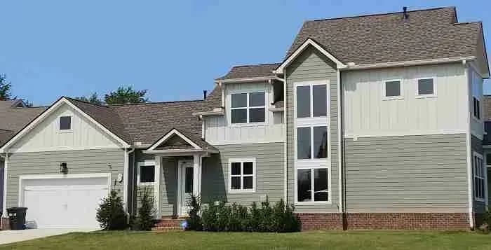 Two-story house with sage siding and a gray shingle roof