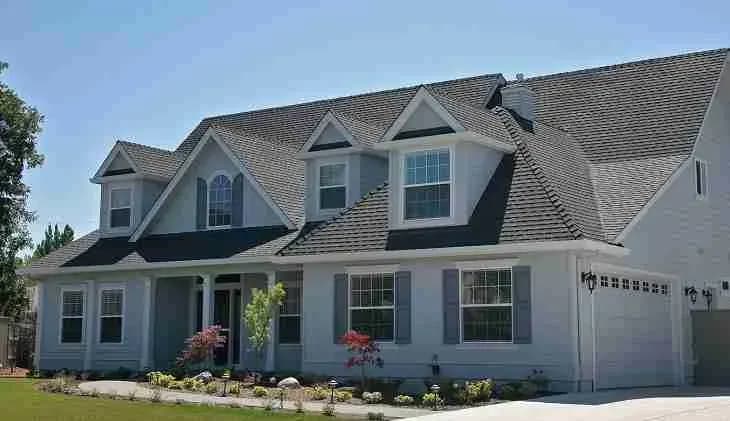 Blue two-story house with dormers and a gray shingle roof