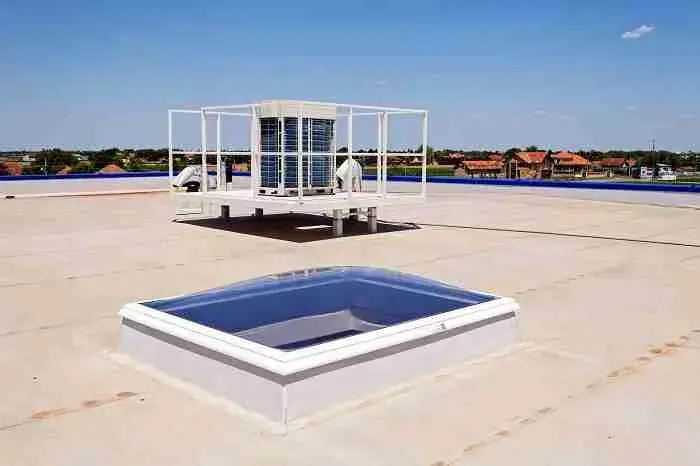 Flat commercial roof with a skylight and a rooftop HVAC unit