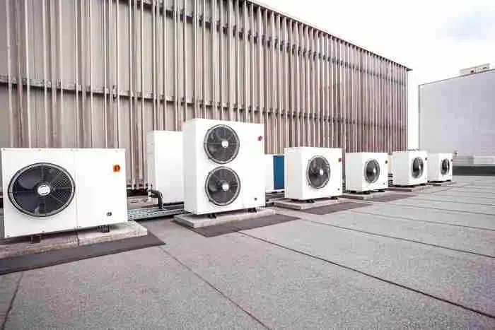 Row of HVAC condenser units on a flat commercial roof