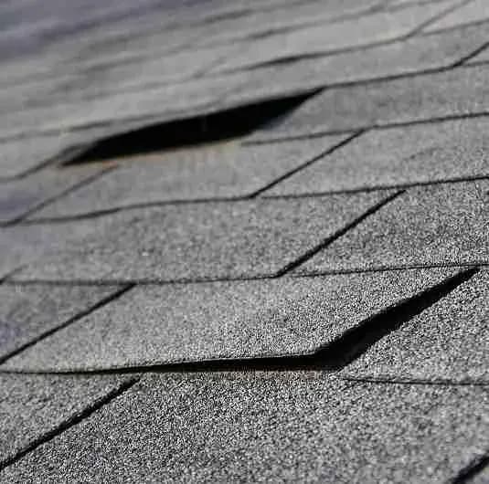Close view of a lifted gray asphalt shingle