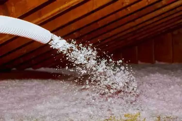 Blown-in insulation being sprayed into an attic