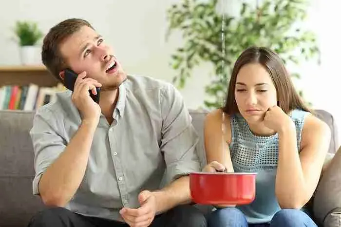 Couple on a couch catching a ceiling leak in a pot
