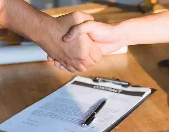 Handshake over a contract on a clipboard