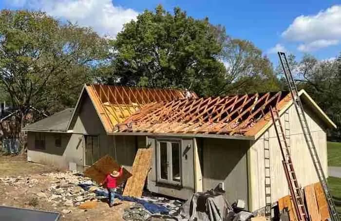 House with the roof torn off to the rafters during reconstruction