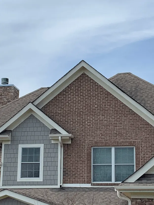 Brick and gray siding house with a shingle roof