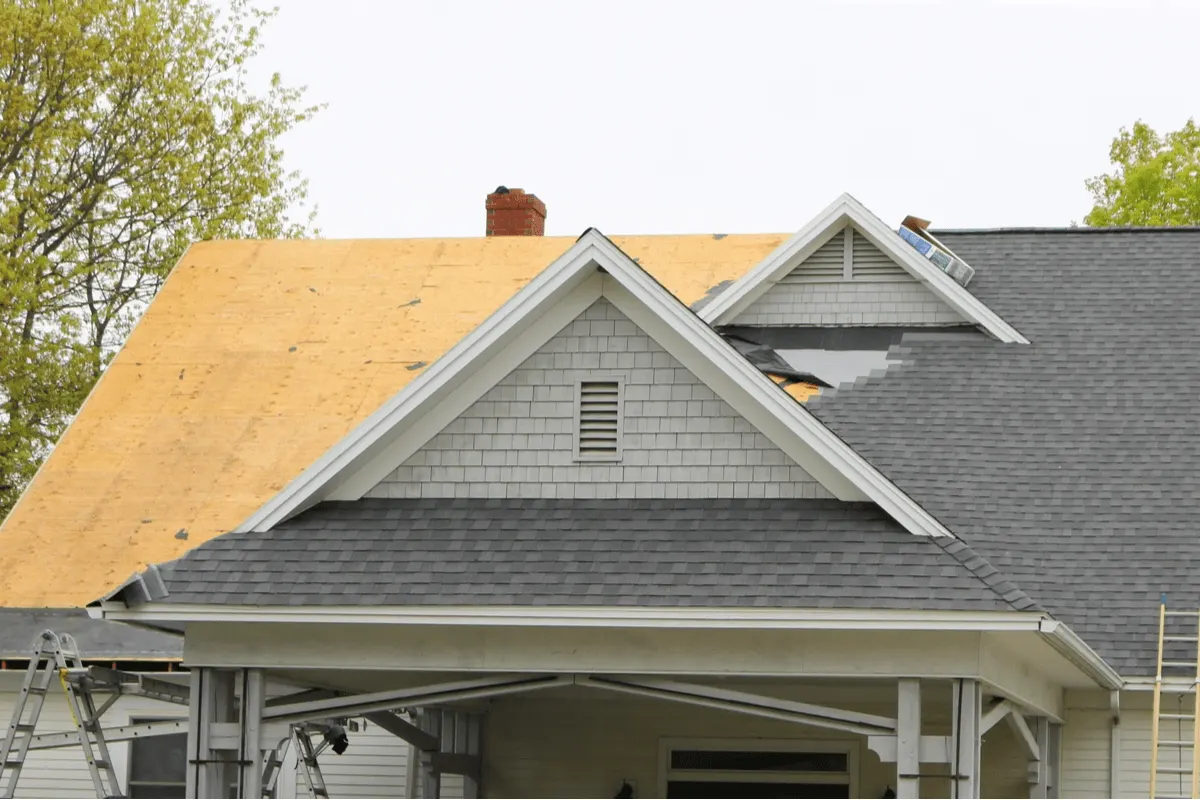 House with part of the roof stripped to the decking during a roof replacement