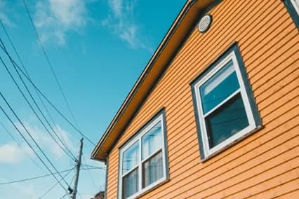 Orange lap siding and windows on a house seen from below