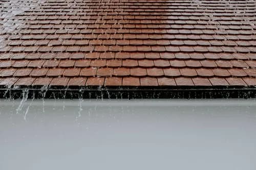 Rain running off a clay tile roof edge