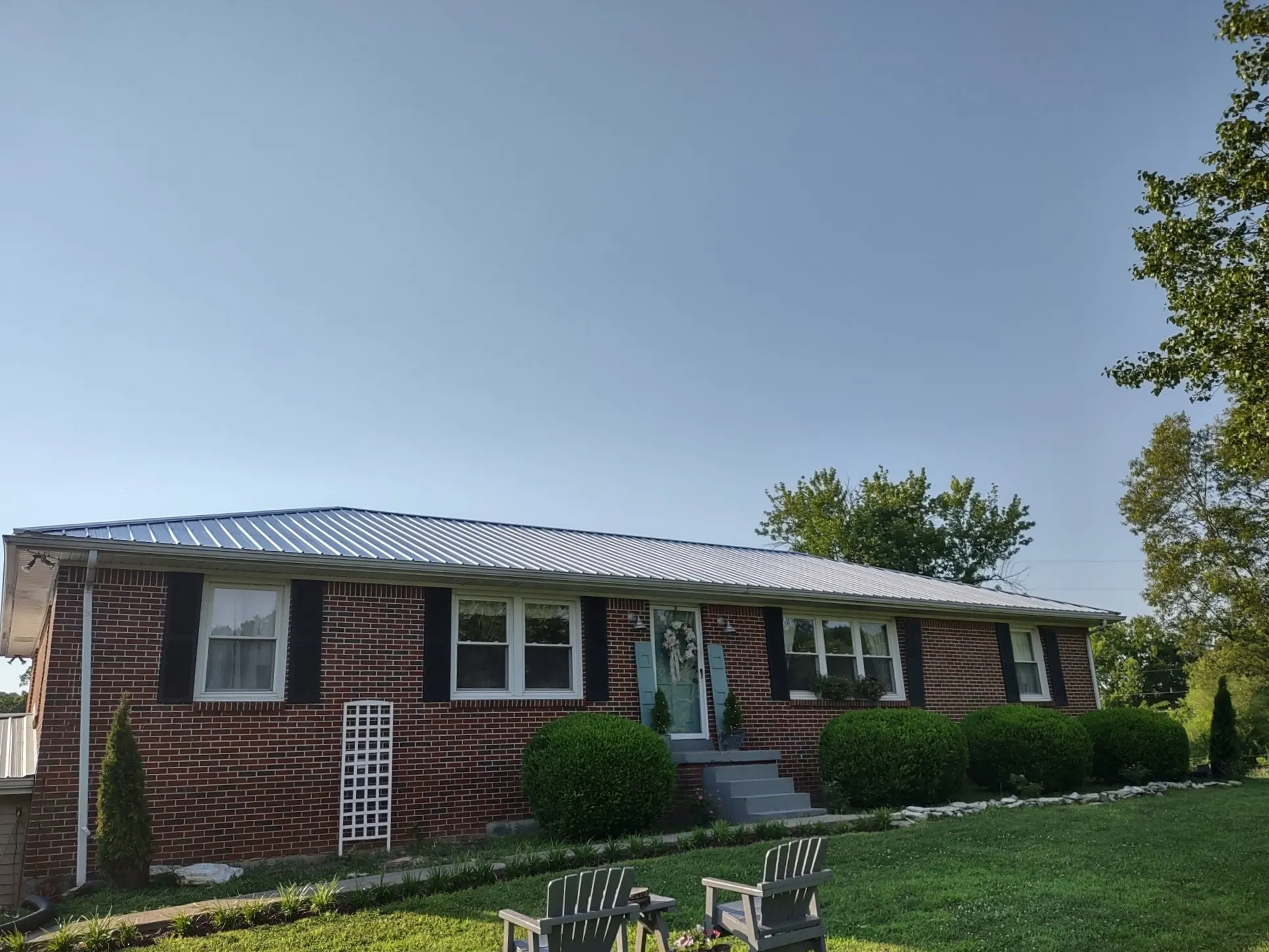 Brick ranch-style home with a newly installed standing seam metal roof, from our Lebanon office's job photos