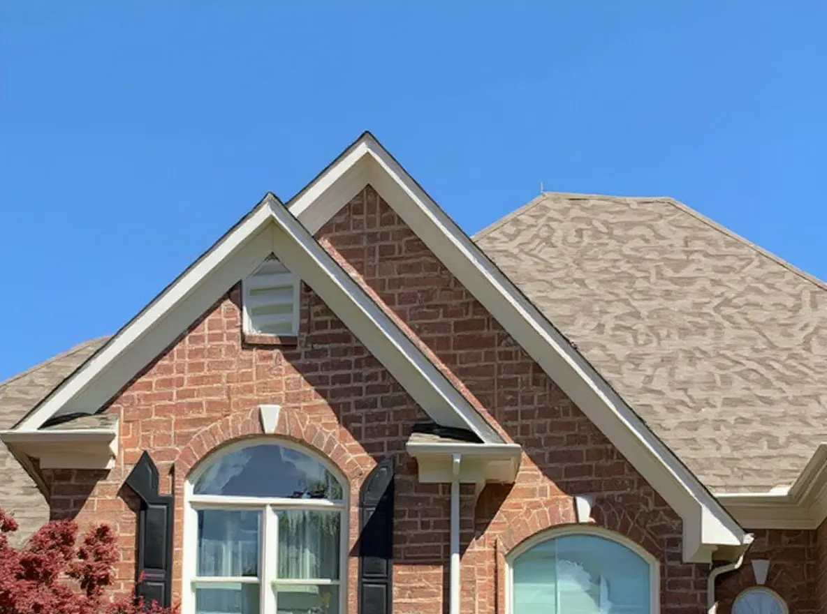 A large brick two-story home with a company branded truck parked in front