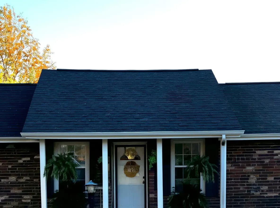 A single-story brick ranch-style home with a dark shingle roof, front porch, and landscaped front yard, photographed from across the street