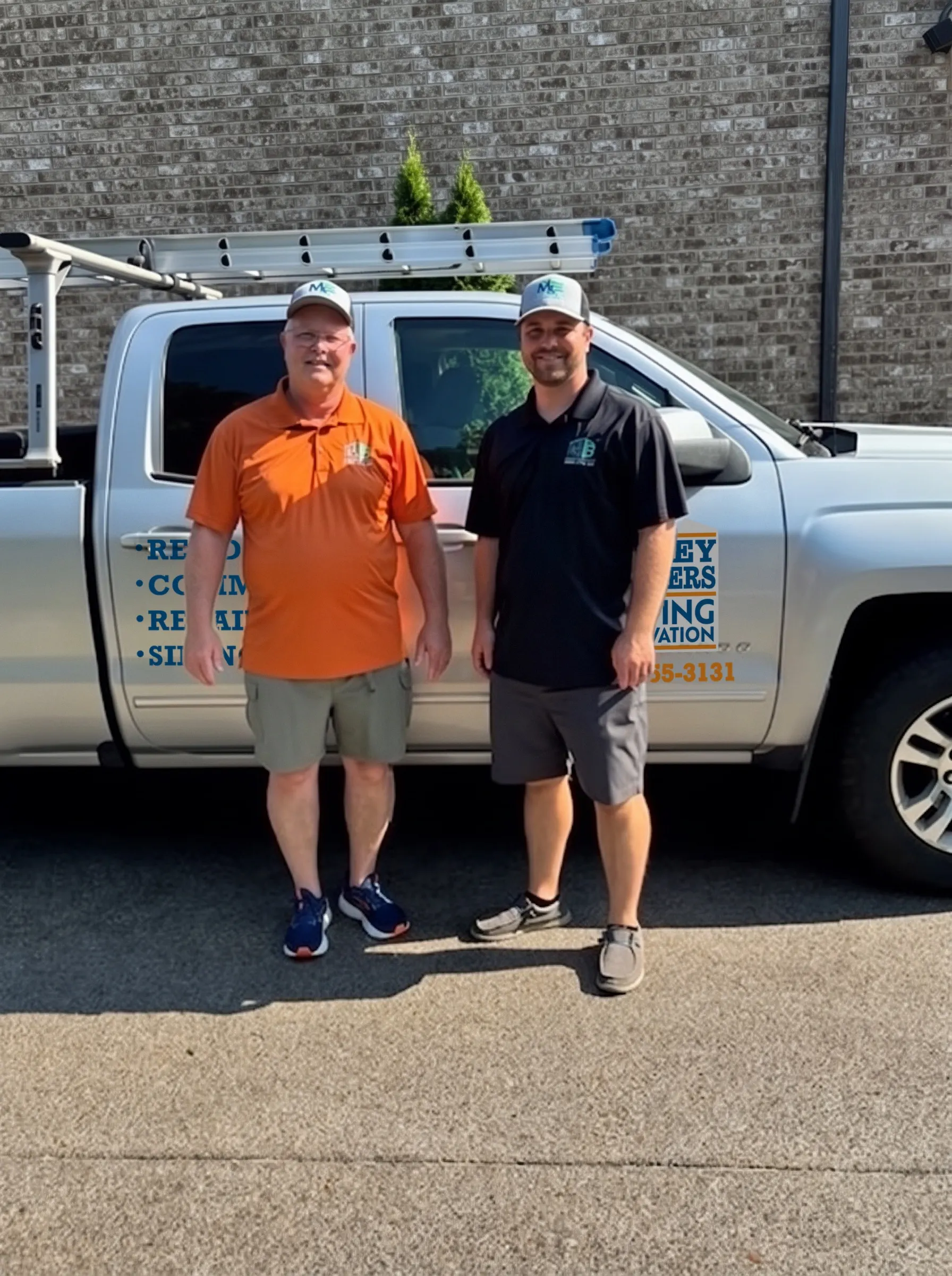 Two men standing in front of a Mobley Brothers pickup truck