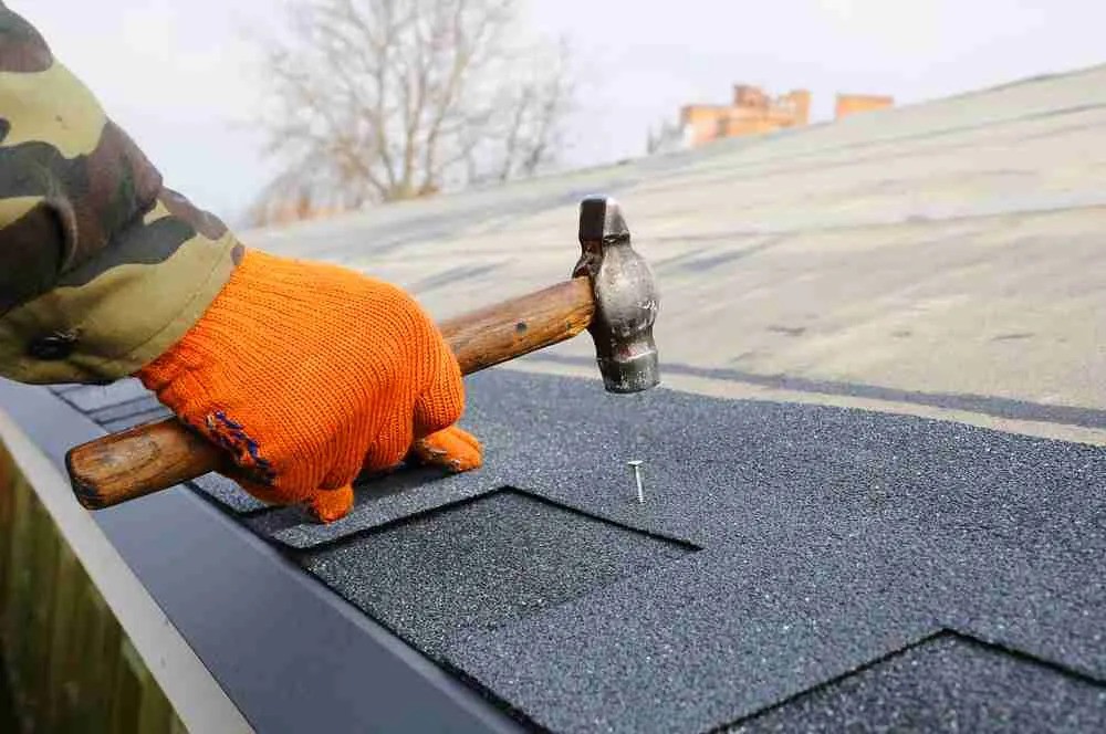Professional performing Brentwood roof repair by replacing damaged asphalt shingles
