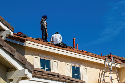 Two members of the Mobley Brothers team working on top of a roof in Nashville